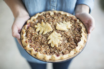 A woman's hands holding a freshly baked pie.