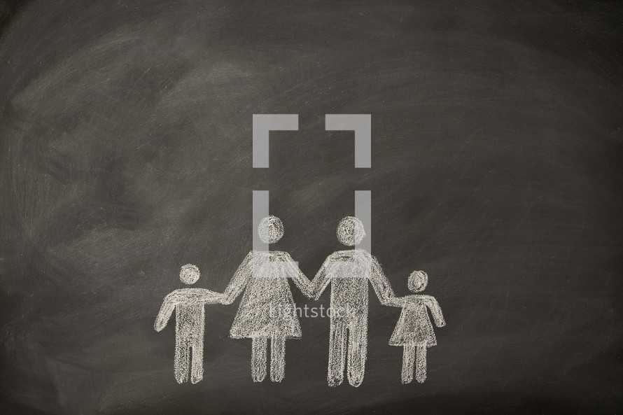 A simple drawing on a chalkboard of a family holding hands.