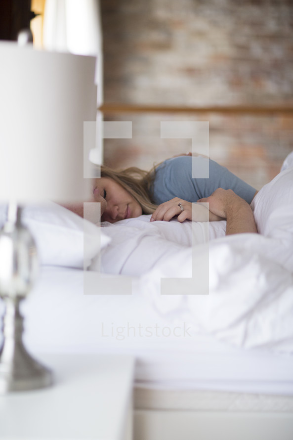 a couple lying in bed snuggling 