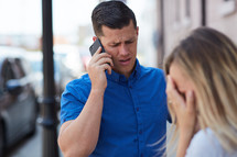 a man talking on a cellphone and a frustrated woman 