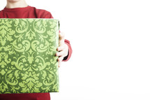 A man holding out a gift wrapped in green wrapping paper