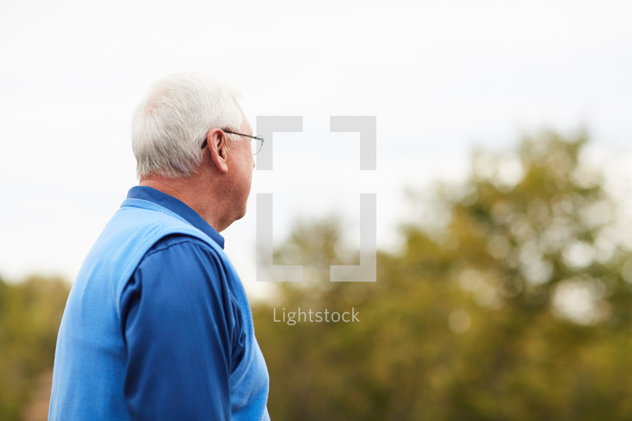 elderly man standing outdoors 