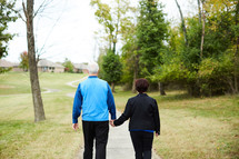 mature couple walking holding hands 
