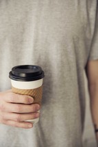 man holding a paper coffee cup 