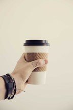 hand holding a paper coffee cup 