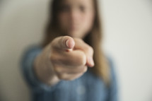 a woman pointing her finger straight at the camera.