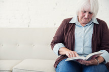 an elderly woman reading the Bible