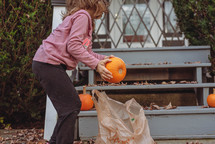 girl decorating with pumpkins 