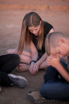 kids praying in a desert 