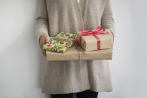 torso of a woman holding  Christmas gifts