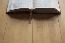 open Bible on a wood floor