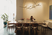 a woman sitting alone at a dining table 