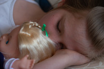 child sleeping with a doll 