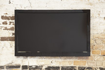blank tv screen on brick wall