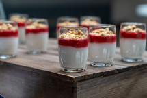 White and red healthy cream yoghurt desert with granola oats, artisan food pudding, served in glass