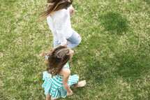 mother and daughter walking holding hands outdoors 