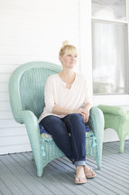 woman sitting in a chair on a front porch 