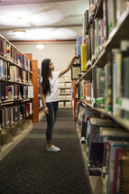 woman looking at books in a library 