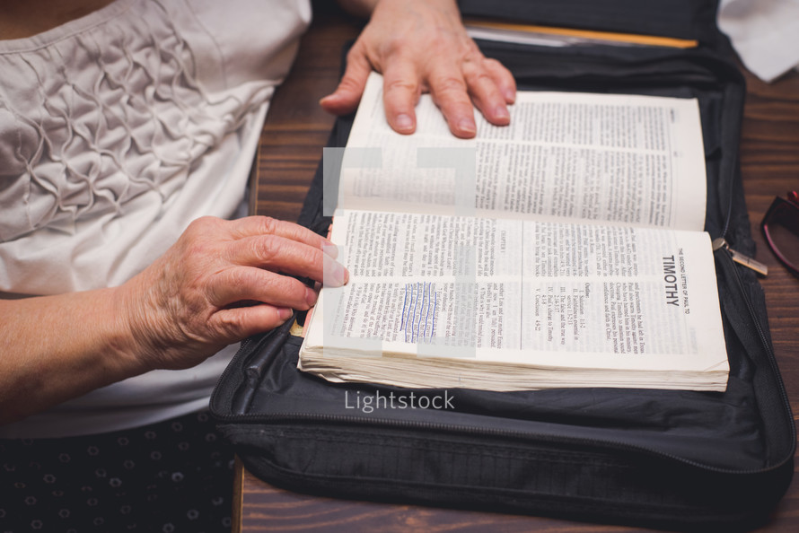 elderly woman reading a Bible  and the book of Timothy