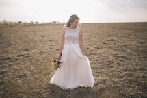a fall bride standing in a horse pasture 