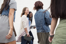 A group of young women holding Bibles and walking together.