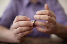 A man taking off his wedding ring. 