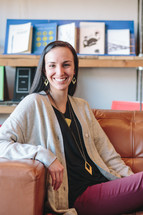 portrait of a smiling woman sitting on a couch 