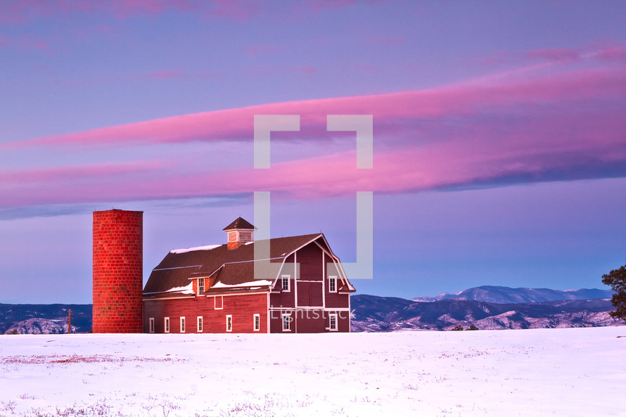Red barn in the snow with the Colorado front range in the background