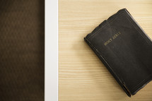Weathered, leather Bible on a table.