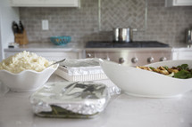 food on a kitchen counter wrapped in tin foil