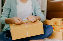 a woman wrapping up a package