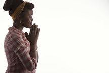teen girl praying alone on white background.