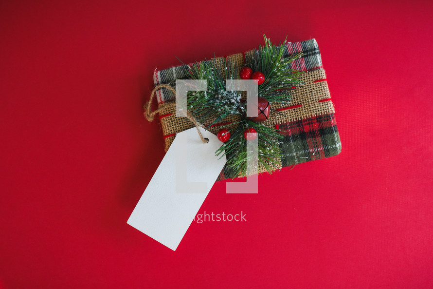 Gift with blank name tag on a red background