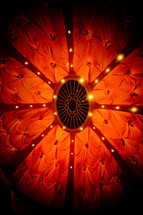 lights at the top of a red fabric tent