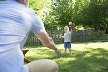 father and son throwing a baseball  together. 
