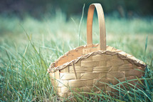 Empty gold Easter basket sitting in grass