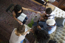woman's group Bible study having a discussion and prayer in a living room 