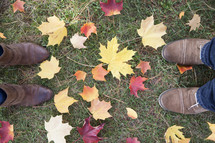 boots standing in grass and fall leaves 