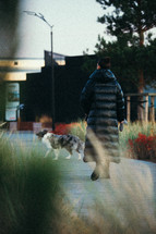 Woman in heavy coat walking her dog