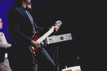 a man playing an electric guitar on stage 