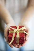 a woman holding a wrapped Christmas gift. 
