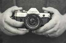 man holding a canon camera 