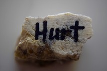 word Hurt written on a rock 