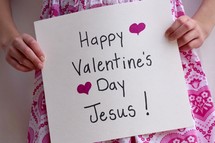 A little girl holding a Happy Valentine's Day Jesus sign 