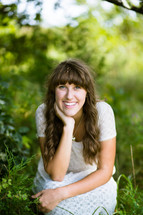 a woman with bangs smiling outdoors 