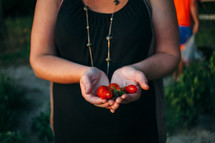 a woman holding summer tomatoes 