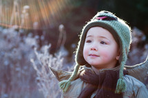 a toddler boy standing outdoor in winter 