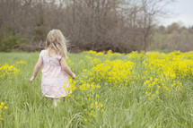 A child in a field of yellow flowers.