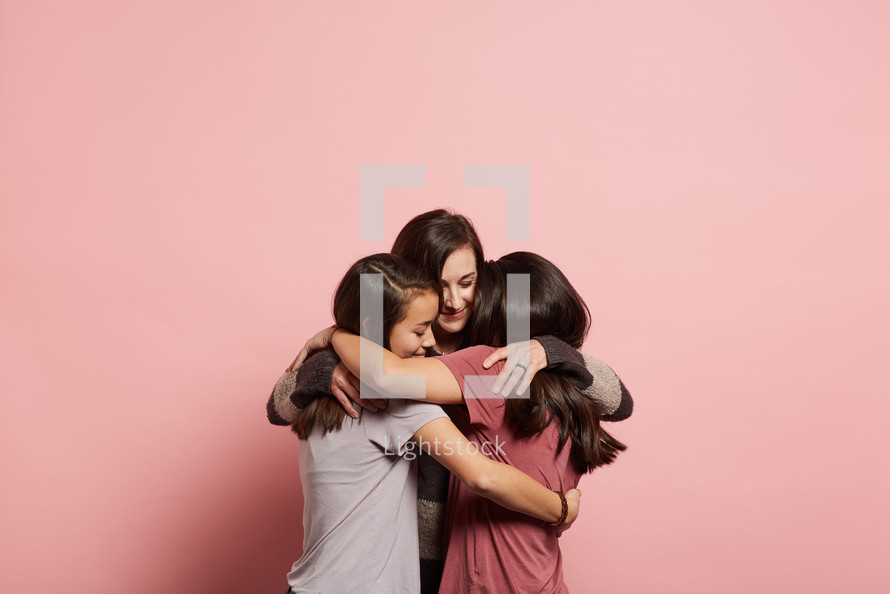 mother and daughters hugging 
