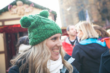 face of a smiling woman standing outdoors in a winter hat 